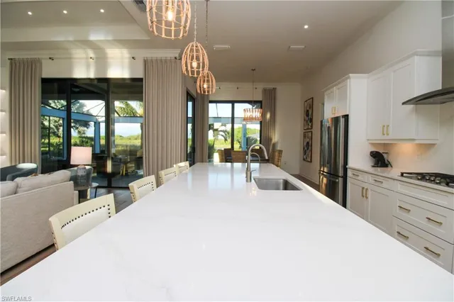 a large kitchen with stainless steel appliances a large window a sink and a large window