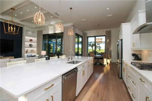 a large white kitchen with a large island oven a stove and a refrigerator