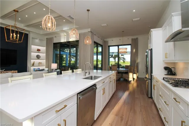 a large white kitchen with a large island oven a stove and a refrigerator