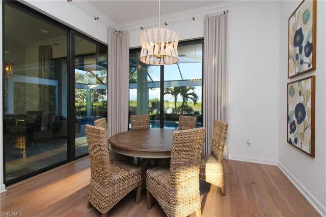 a dining room with furniture a chandelier and wooden floor