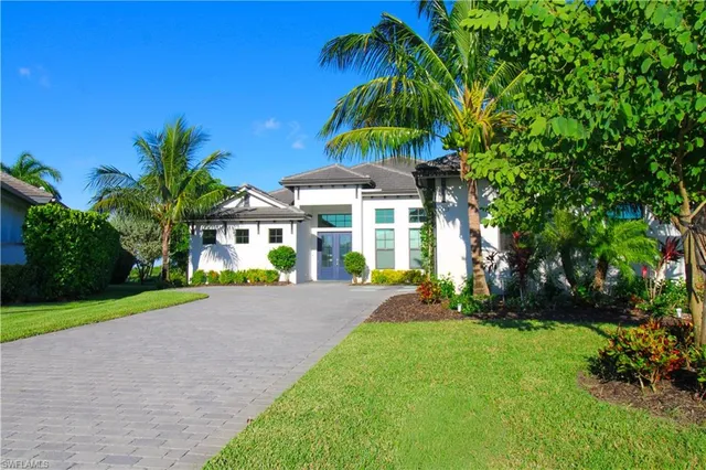 a view of a house with a yard and potted plants