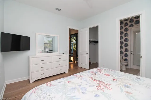 a bedroom with a bed and a flat tv screen in it