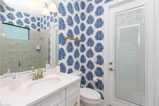 a bathroom with a sink a toilet a mirror and shower curtain