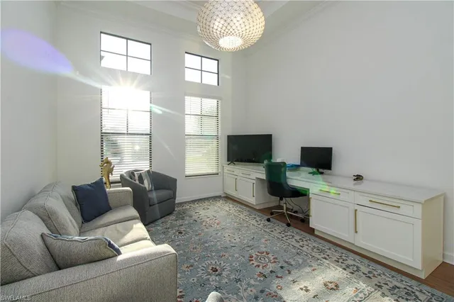 a living room with furniture a flat screen tv and a window