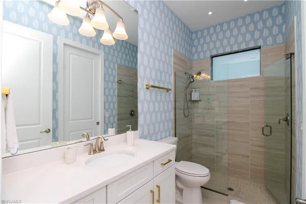 a bathroom with a sink a toilet and shower