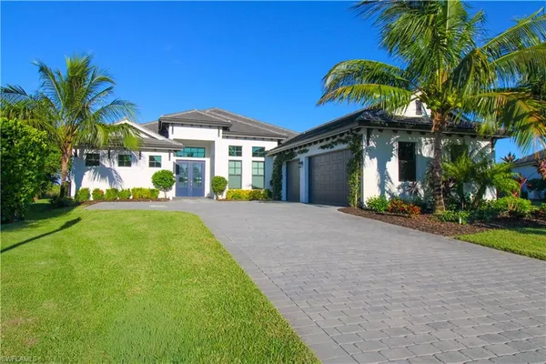 a view of a house with a backyard and a tree