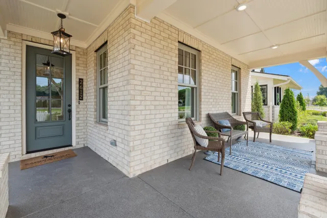 a view of a hallway with wooden floor and a living room