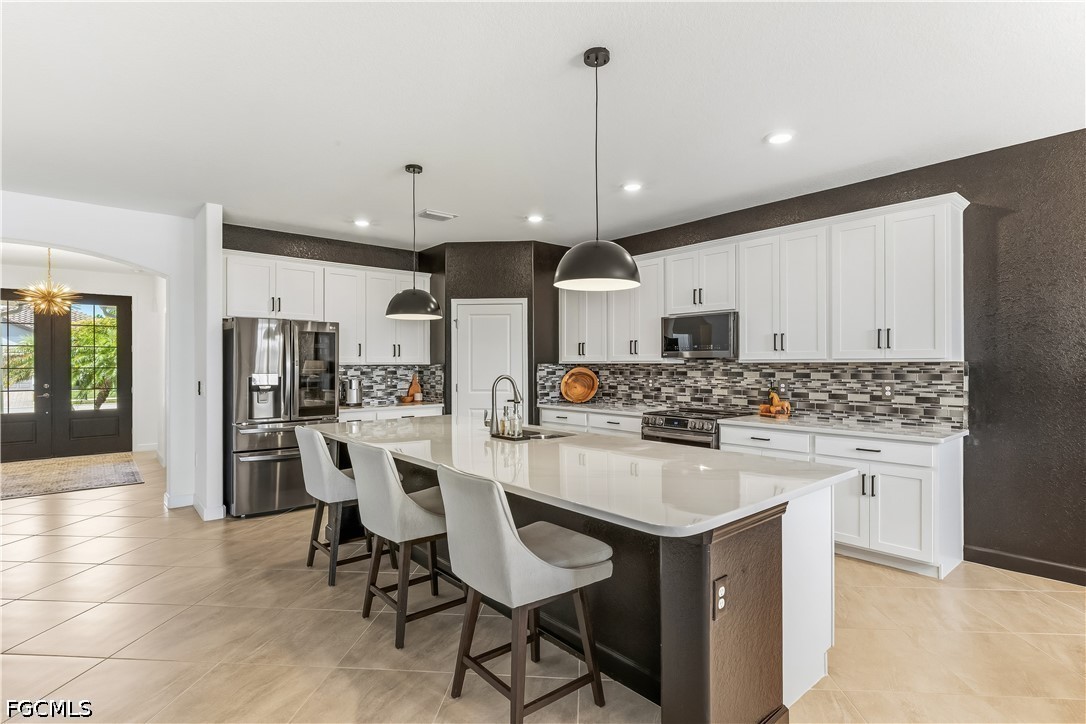 17290 Walnut Run Drive Alva, FL 33920 - Photo 8 of 37 a kitchen with stainless steel appliances kitchen island granite countertop a table chairs and a refrigerator