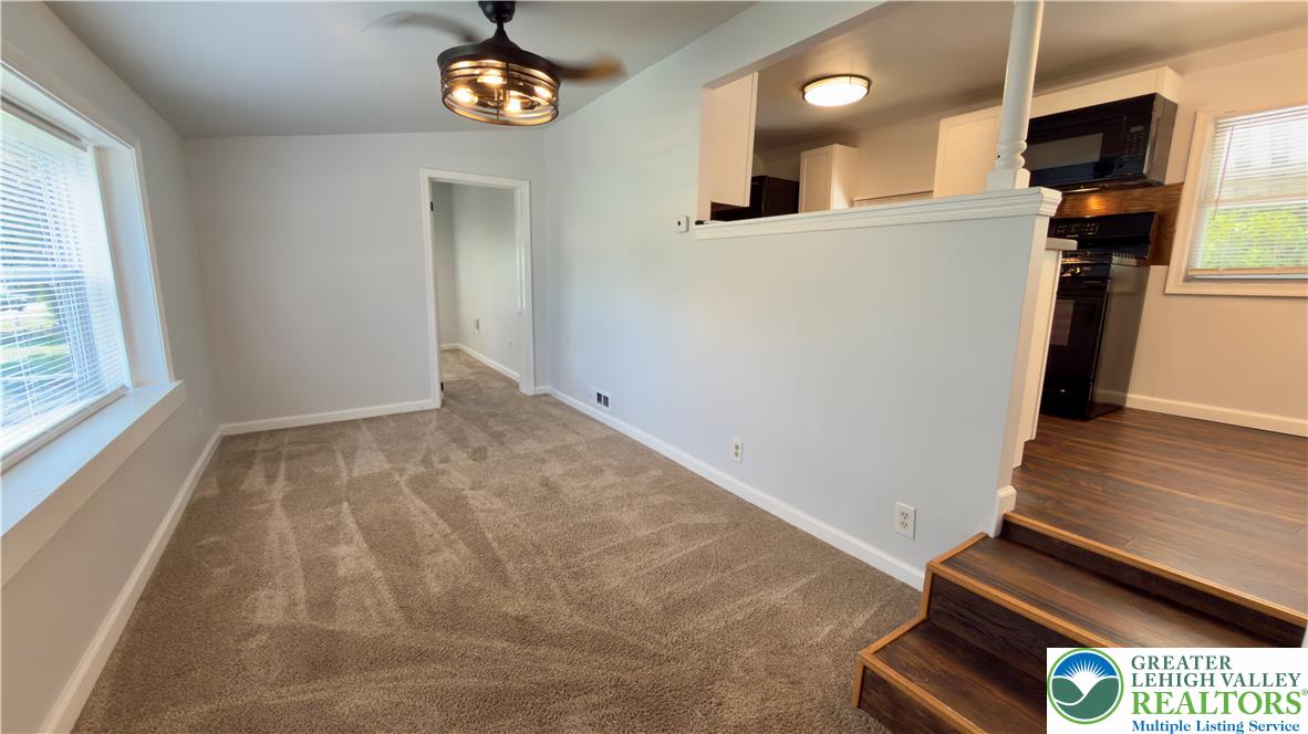 246 Poplar Street Bath, PA 18014 - Photo 9 of 34 A split-level layout seamlessly connects a cozy carpeted living space to a wood-floored kitchen, bathed in natural light.