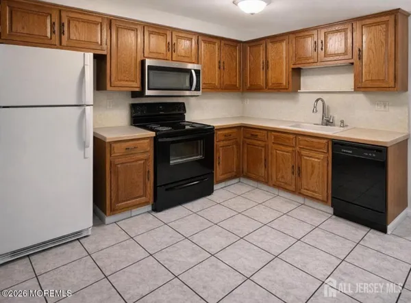 a kitchen with a sink a stove top oven and refrigerator