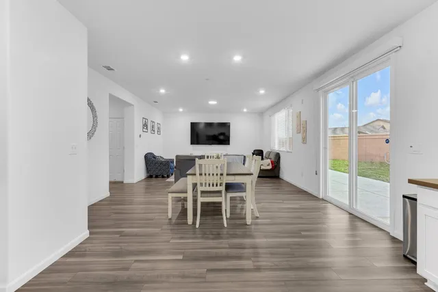 a living room with furniture a flat screen tv and a floor to ceiling window