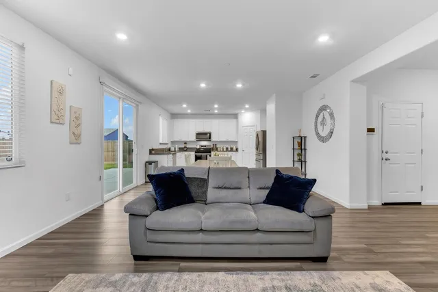 a living room with furniture and wooden floor