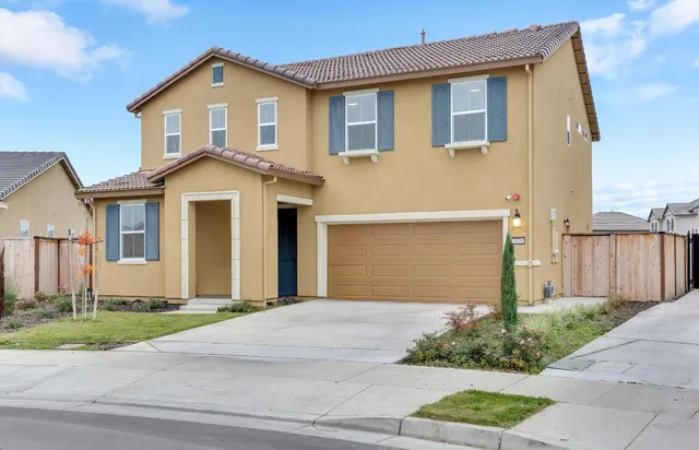 a front view of a house with a yard and garage