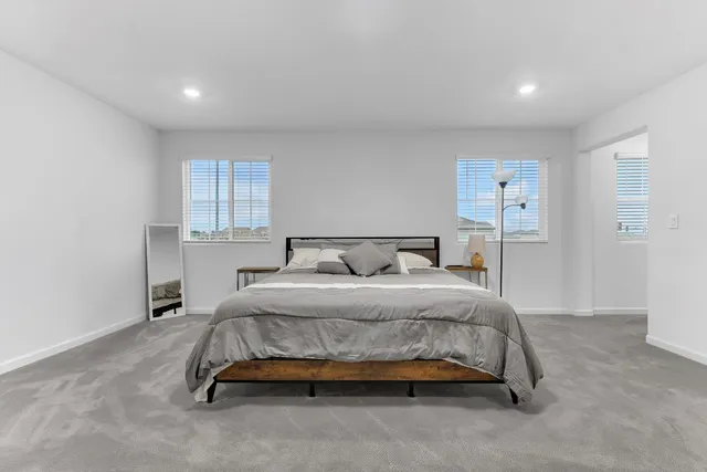 a spacious bedroom with a bed and a window