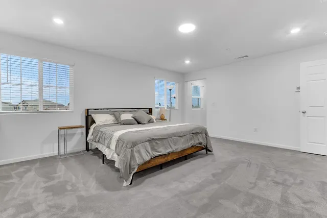 a spacious bedroom with a bed and a window