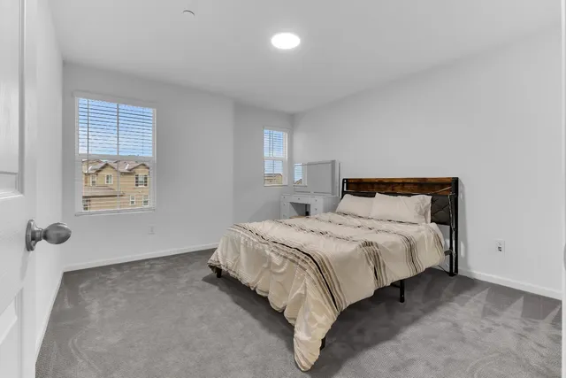 a bedroom with a bed and a painting on the wall