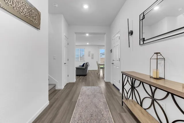 a view of a hallway with wooden floor and staircase