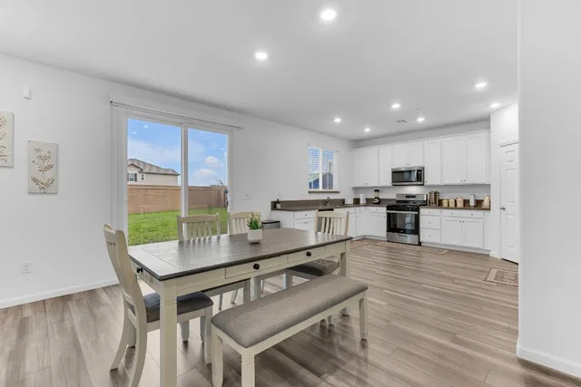 a kitchen with a table chairs microwave and cabinets