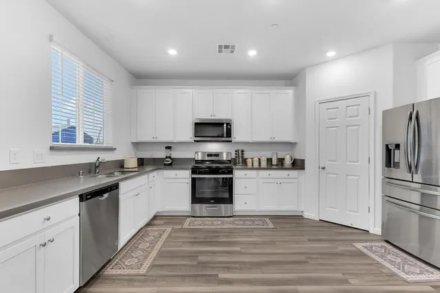 a kitchen with white cabinets and stainless steel appliances
