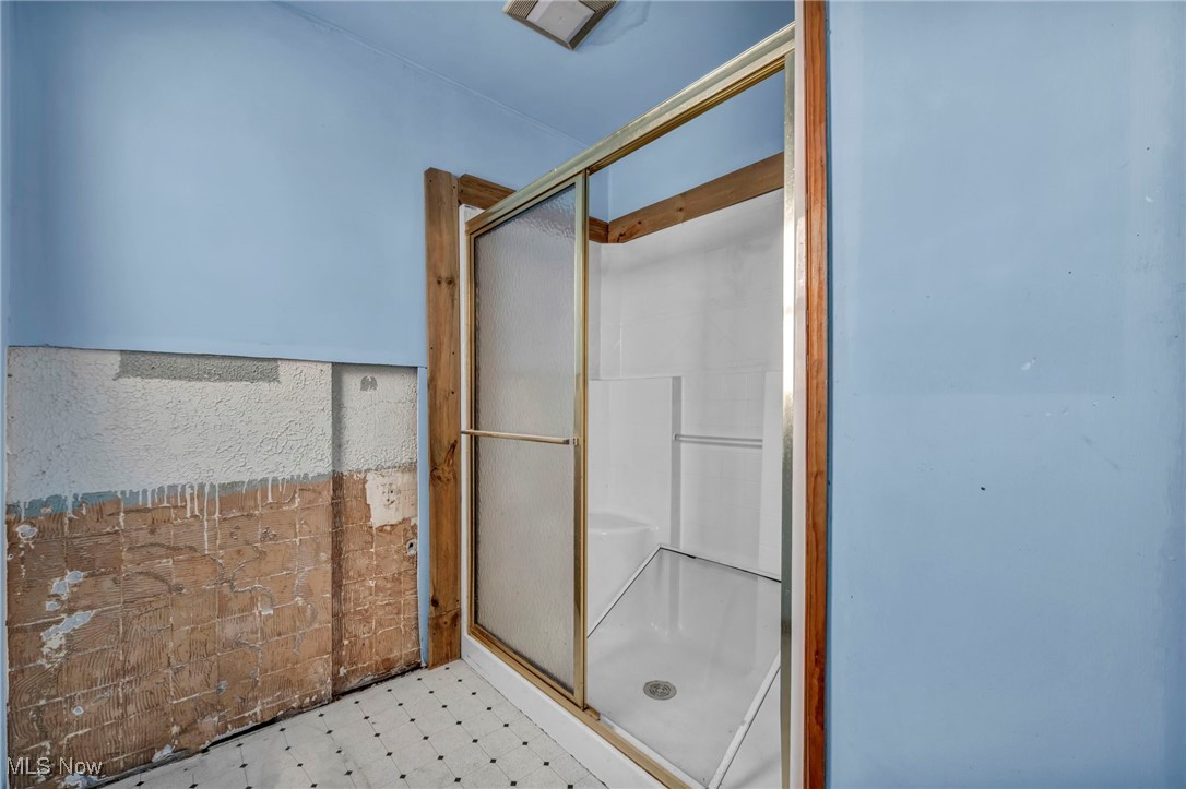 14750 Schreiber Road Maple Heights, OH 44137 - Photo 28 of 44 Bathroom with tile patterned floors, a shower stall, and wainscoting