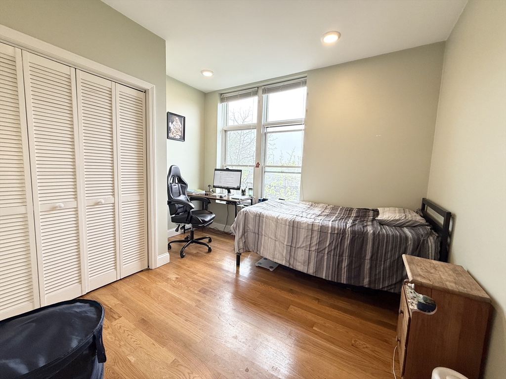 299 Dudley Street, Unit 7 Boston, MA 02119 - Photo 4 of 8 a bedroom with a bed and wooden floor