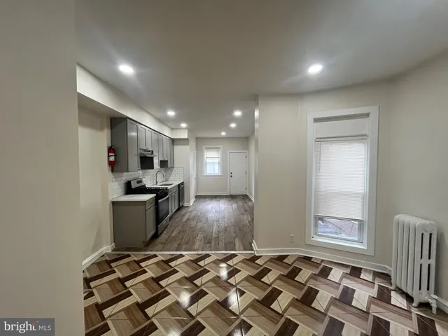 a living room with kitchen island granite countertop furniture a rug and a window