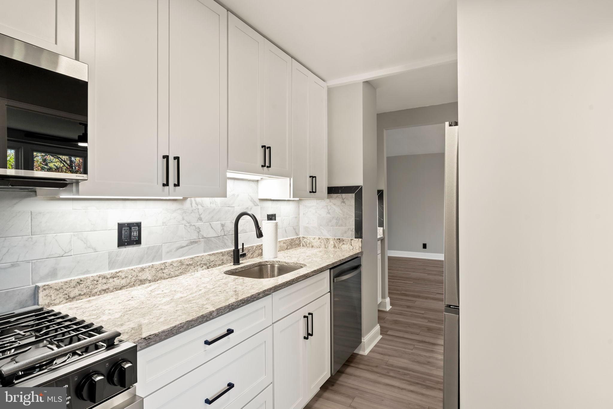 1600 Hagys Ford Road, Unit 3Y Narberth, PA 19072 - Photo 5 of 38 a kitchen with stainless steel appliances granite countertop a sink stove and cabinets