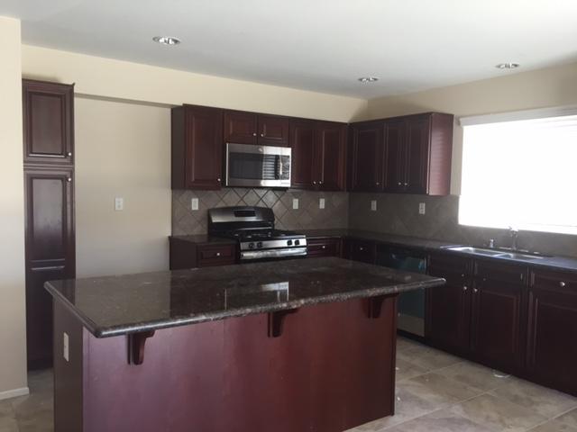 6332 Explorer Way Palmdale, CA 93552 - Photo 2 of 8 a kitchen with kitchen island granite countertop a sink stove and microwave