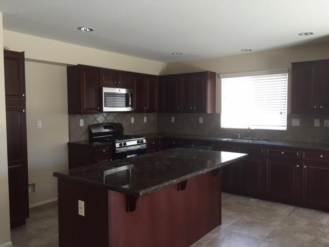 6332 Explorer Way Palmdale, CA 93552 - Photo 3 of 8 a kitchen with granite countertop a sink a stove and refrigerator