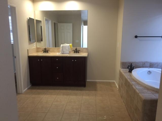 6332 Explorer Way Palmdale, CA 93552 - Photo 6 of 8 a bathroom with a tub sink and mirror