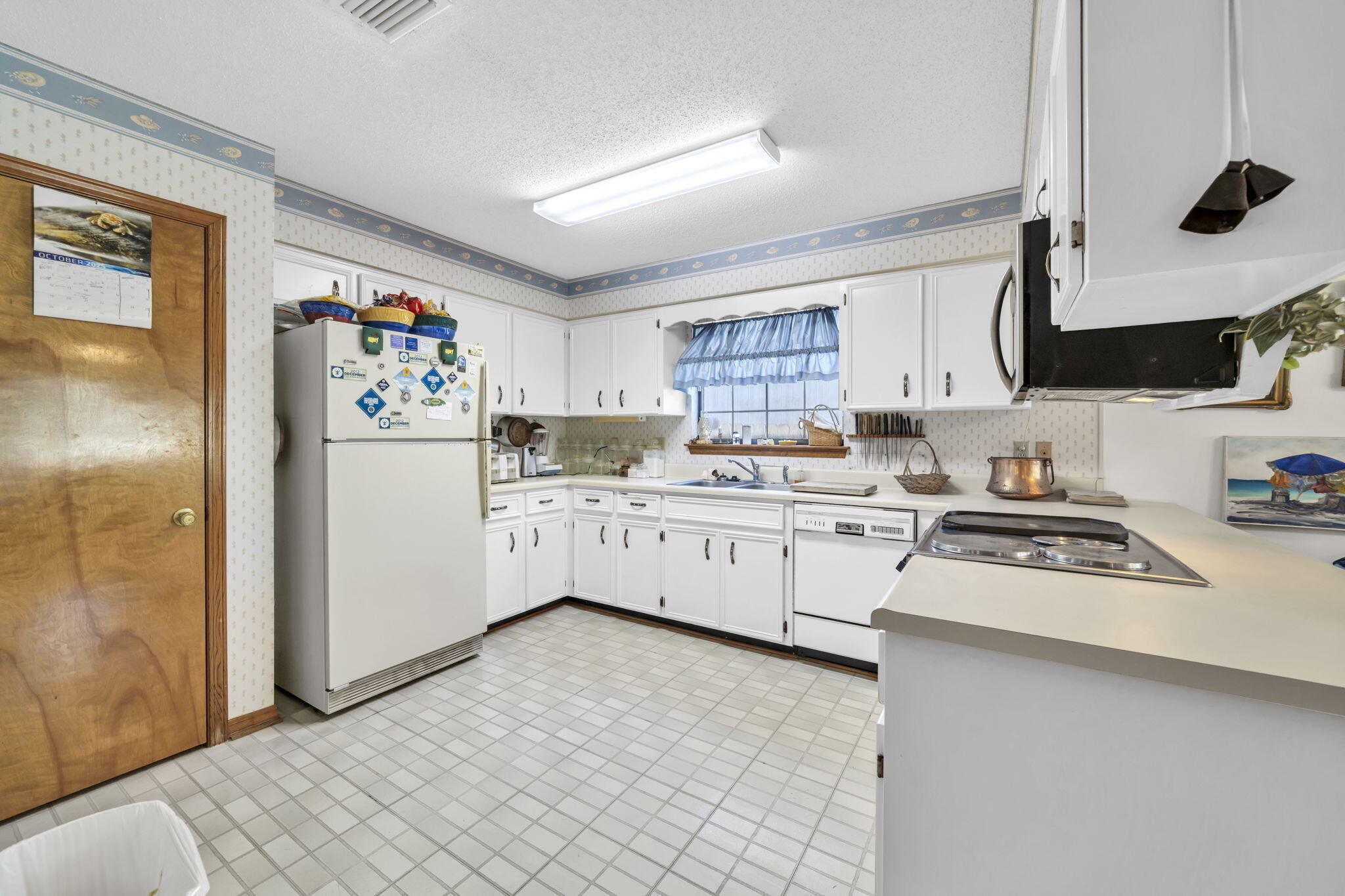 392 Evergreen Circle Destin, FL 32541 - Photo 7 of 32 a kitchen with white cabinets and white appliances