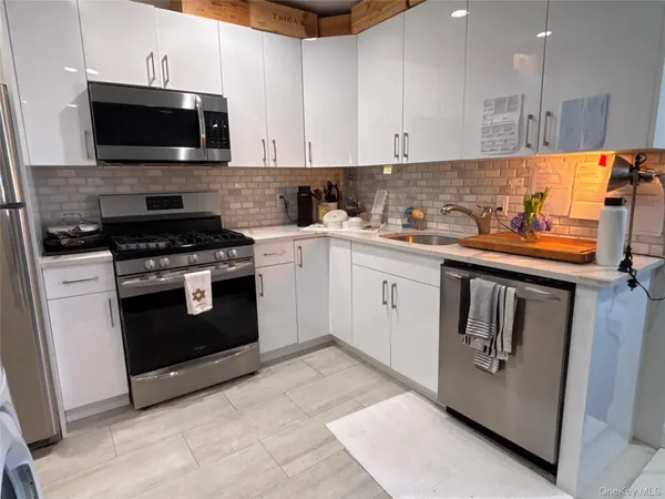 a kitchen with stainless steel appliances granite countertop a stove a sink and a microwave