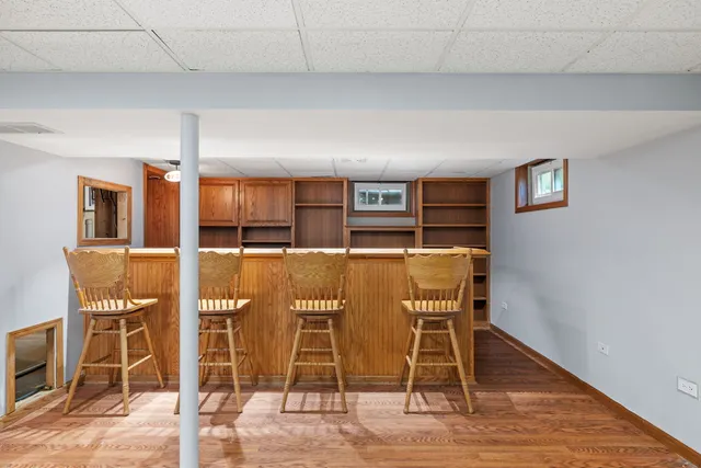 a dining room with wooden floor and windows