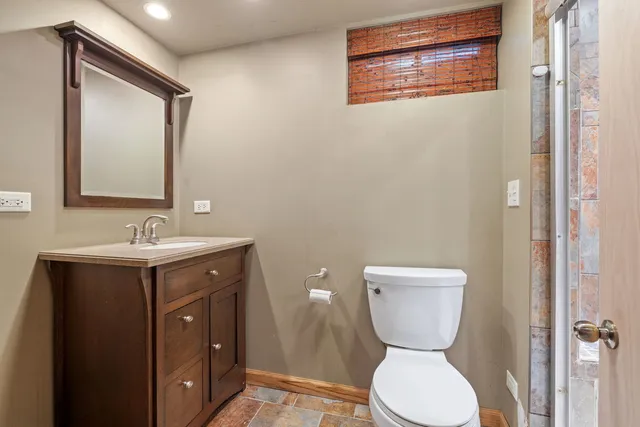 a bathroom with a toilet sink and mirror