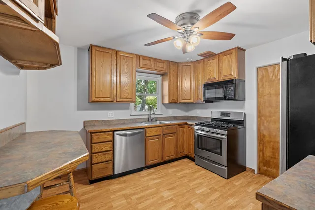 a kitchen with stainless steel appliances granite countertop a stove cabinets and refrigerator