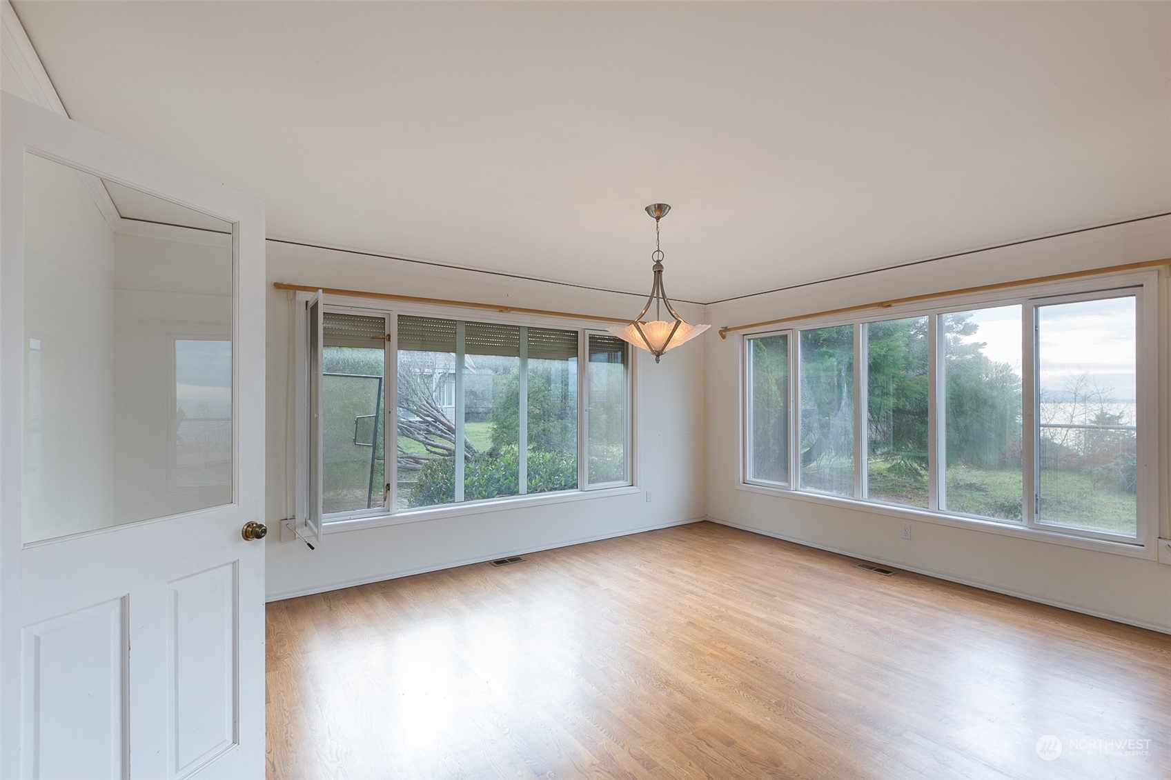 193 Mariners Point Road Sequim, WA 98382 - Photo 4 of 36 a view of an empty room with wooden floor and a window