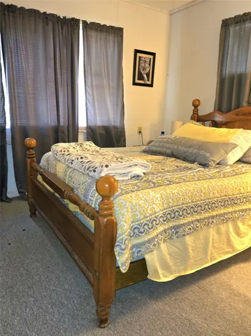 a bed sitting in a bedroom next to a wooden cabinet