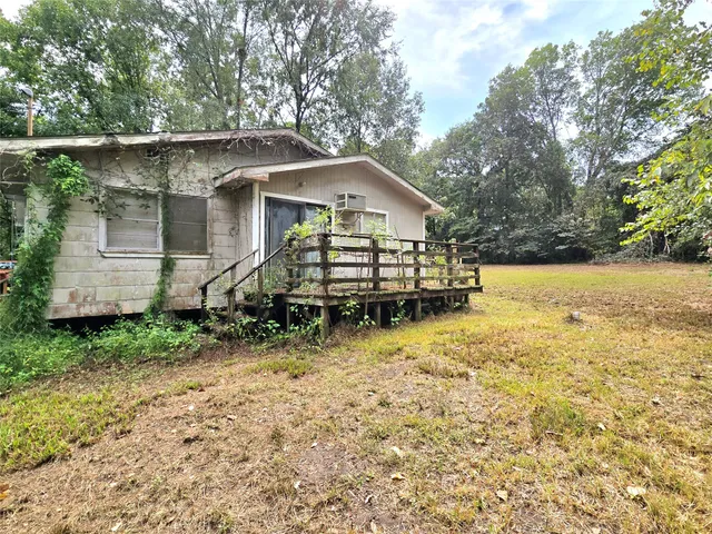 a view of backyard of house with wooden deck and seating area