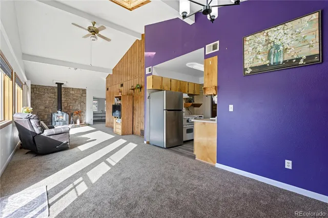 a view of a kitchen with refrigerator and a stove top oven
