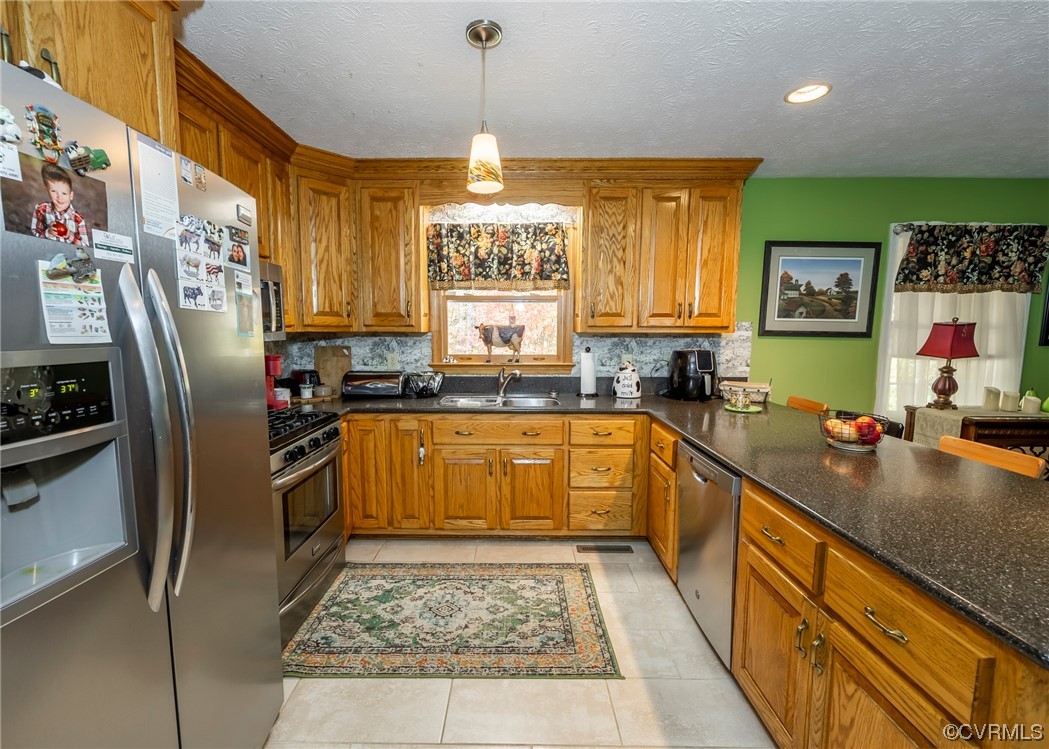 175 Walton Road Keysville, VA 23947 - Photo 30 of 49 a kitchen with stainless steel appliances granite countertop a refrigerator a sink dishwasher a stove and a dining table with wooden floor