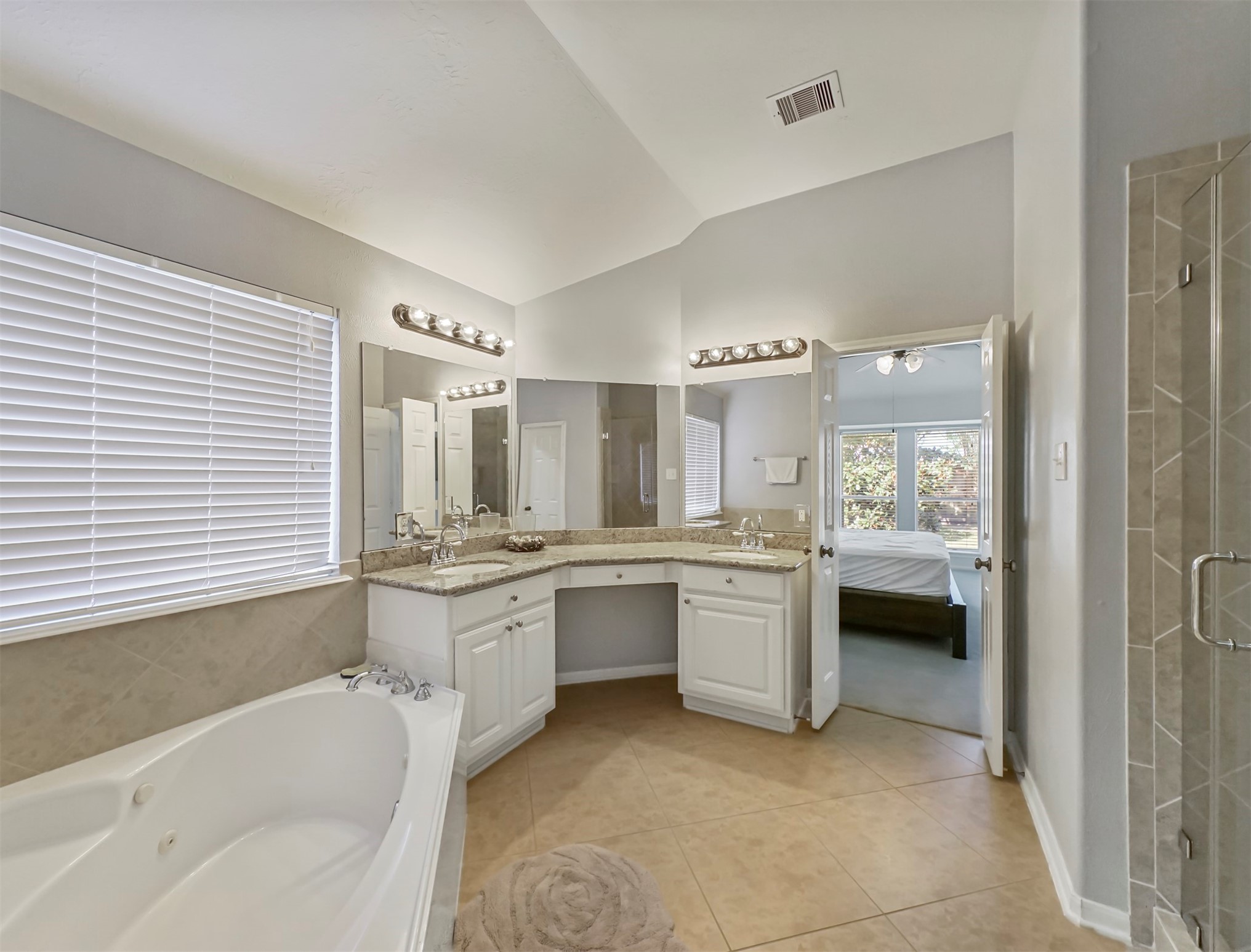 8214 Garrison Point Drive Houston, TX 77040 - Photo 19 of 37 a bathroom with a granite countertop tub a sink and a large mirror