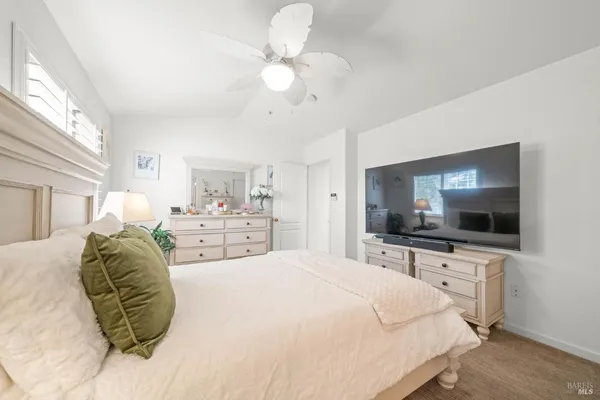 a spacious bedroom with a bed and a flat screen tv