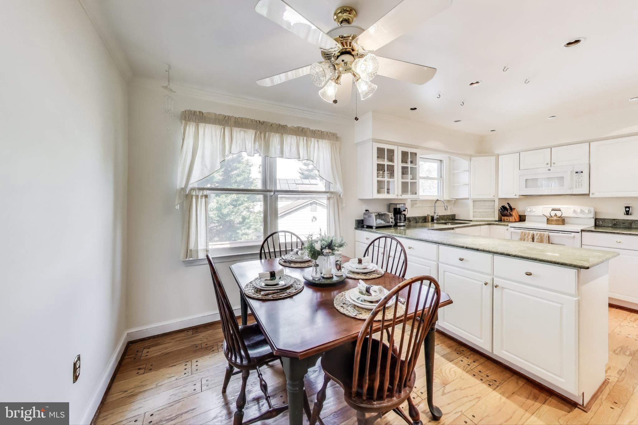 9201 Centerway Road Gaithersburg, MD 20879 - Photo 11 of 53 a view of a dining room with furniture window and wooden floor