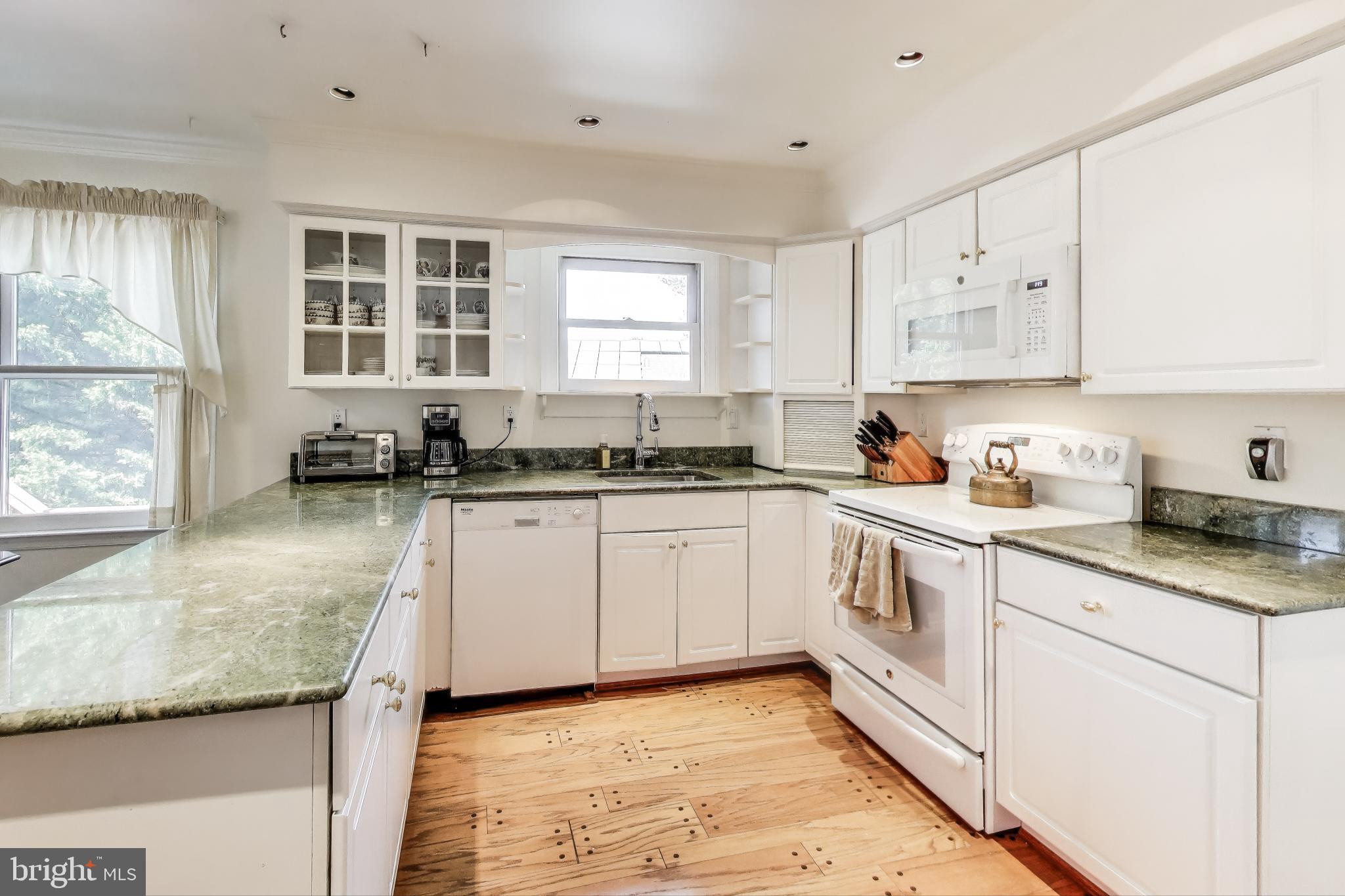 9201 Centerway Road Gaithersburg, MD 20879 - Photo 8 of 53 a kitchen with granite countertop white cabinets white appliances a sink and a window