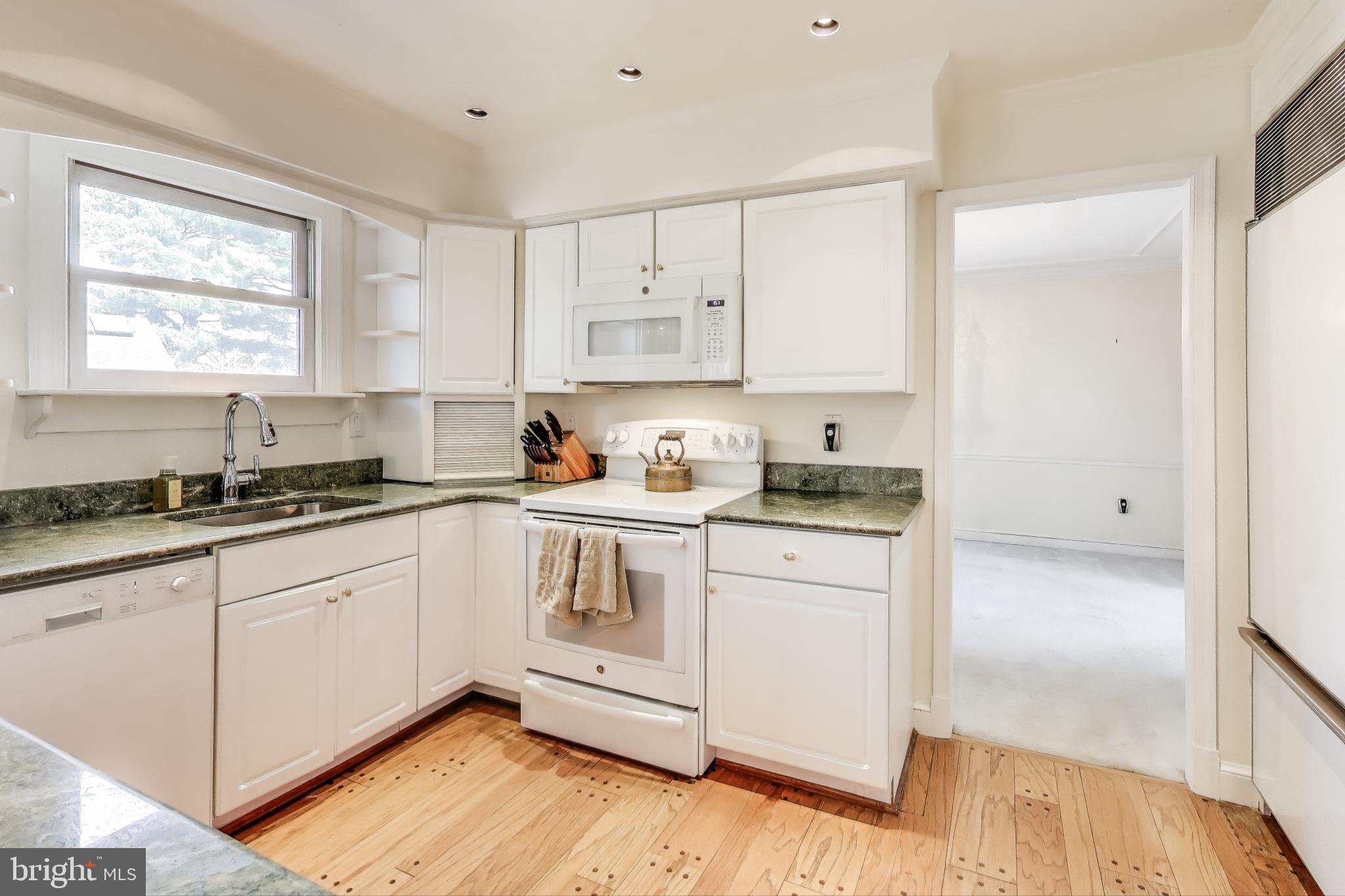 9201 Centerway Road Gaithersburg, MD 20879 - Photo 9 of 53 a kitchen with granite countertop white cabinets white appliances a sink and a window