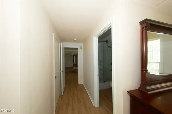a view of a hallway with wooden floor and closet