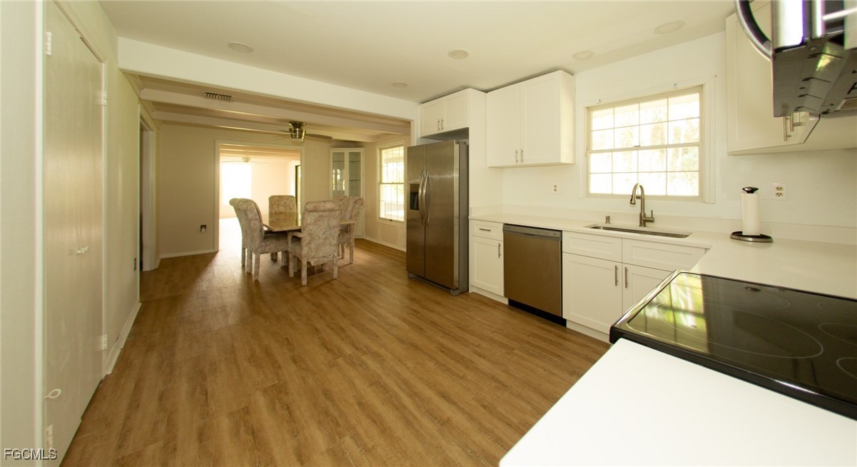 4055 County Road 78 Fort Denaud, FL 33935 - Photo 9 of 28 a view of a kitchen with kitchen island a sink wooden floor and a large window