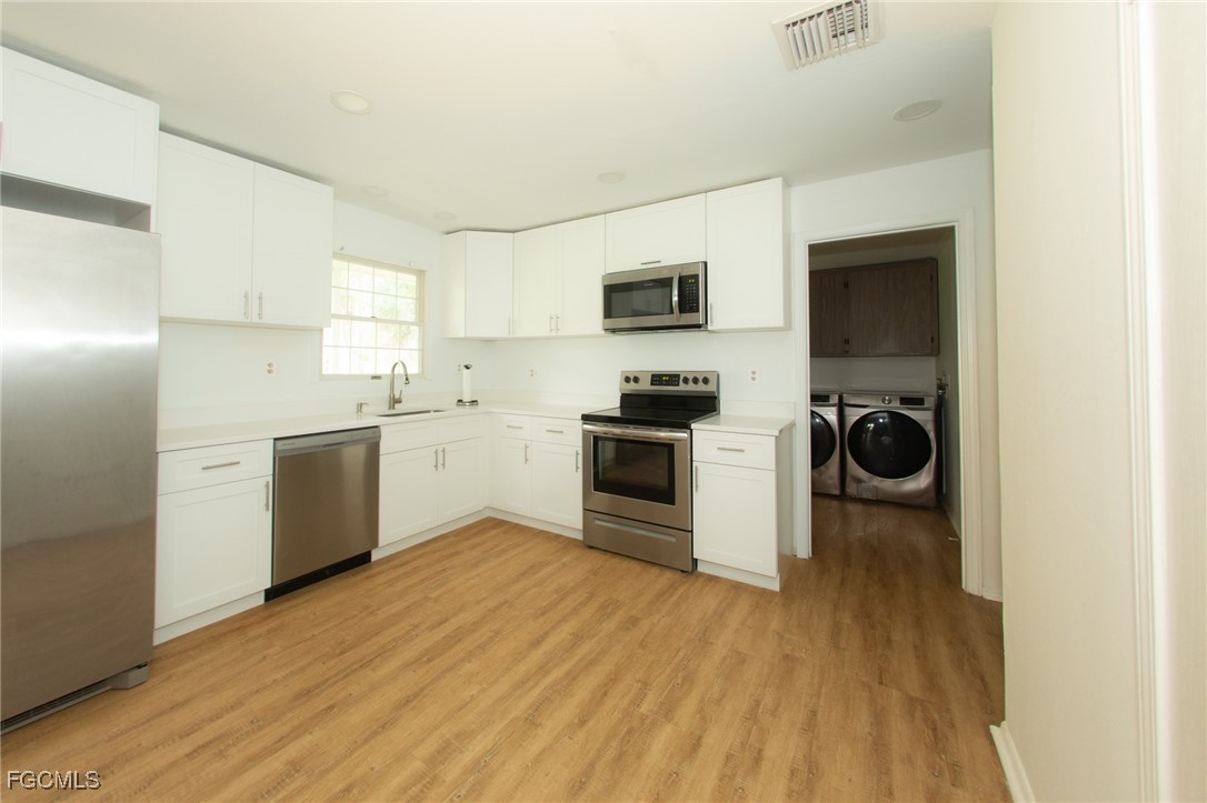 4055 County Road 78 Fort Denaud, FL 33935 - Photo 10 of 28 a kitchen with stainless steel appliances a white cabinet and a stove top oven