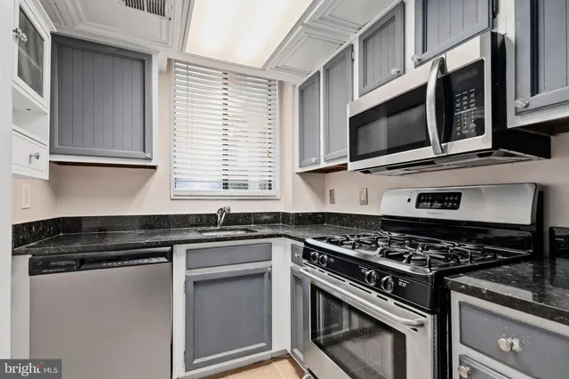 a kitchen with stainless steel appliances granite countertop a stove and a microwave