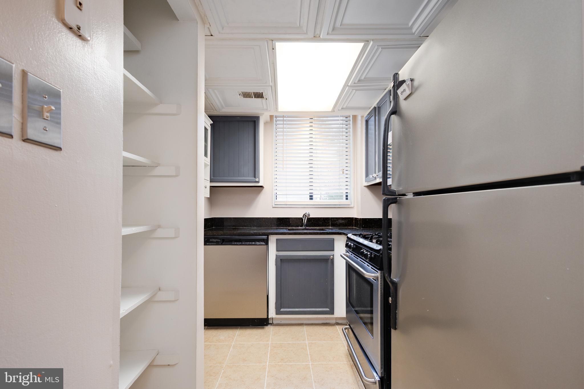3825 Davis Place Northwest, Unit 103 Washington, DC 20007 - Photo 7 of 26 a kitchen with stainless steel appliances granite countertop a refrigerator and a sink